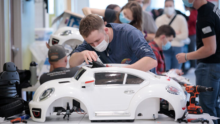 Ethan Bowles, a senior biological systems engineering major, makes an adjustment to the steering wheel in an electric car during the GoBabyGo! build on April 2. Bowles was among seven Huskers to assist with the project. This was his third time volunteering for the event.