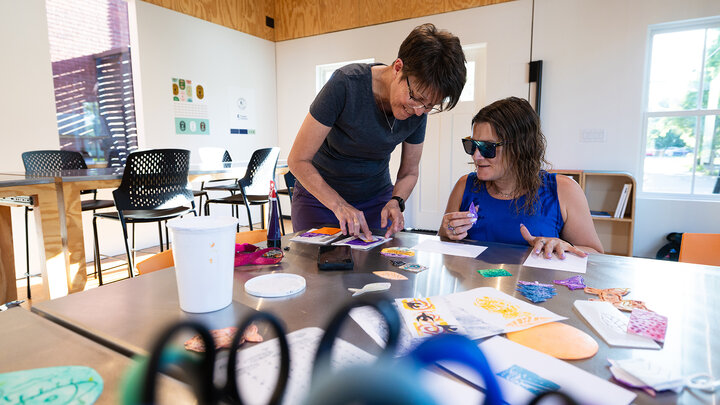 Jean Stryker (left) shows Jessica Hernandez how to dip a stamp into paint for a printmaking activity at the Art Chapel on June 30. The Art Chapel is part of the church's community outreach, providing an accessible space for people to pursue creativity at no to low cost. Open studio time is available from 6 to 9 p.m. each Monday at the chapel.