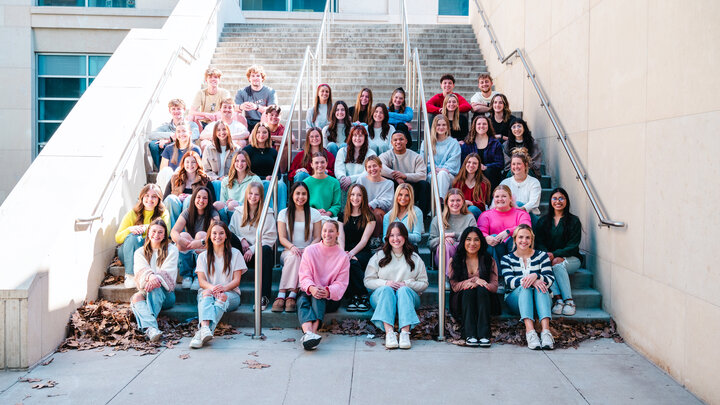 Forty-four students sit on an outdoor staircase.
