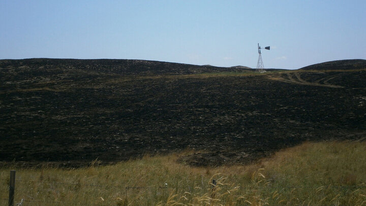 A windmill stands in a charred field in western Nebraska.