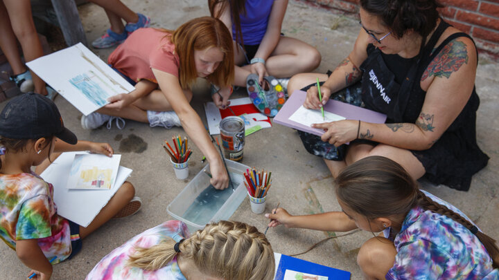 A counselor helps art students