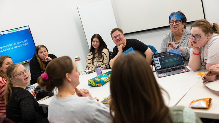People surround a table at the Barkley Speech Language and Hearing Clinic.