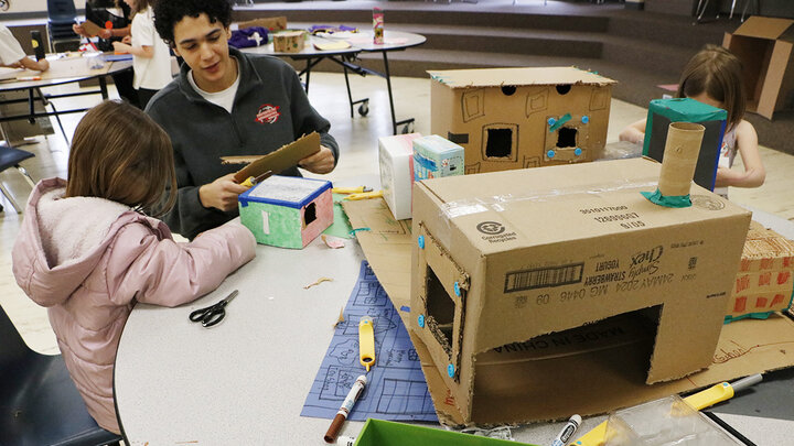Honors student and Engineering Ambassador Adam Algahimi helps a student at Calvert Elementary work on her CityBuild model.