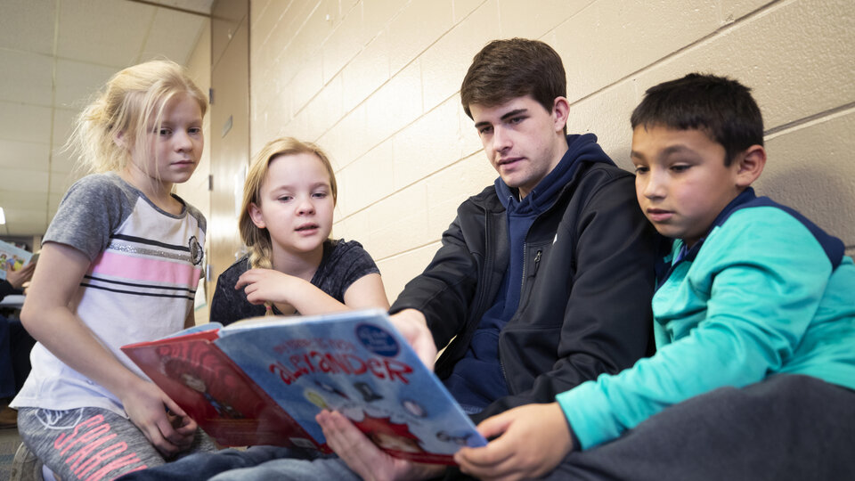Student reading to children